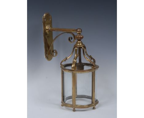 A lacquered brass shaped circular wall mounted lantern, scroll bracket and fluted finial above six serpentine glass panels, 3
