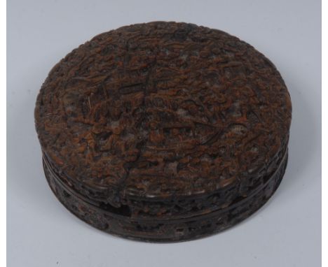 A Chinese tortoiseshell circular snuff box, deeply carved overall with figures amongst pagodas and blossoming prunus, 9.5cm d