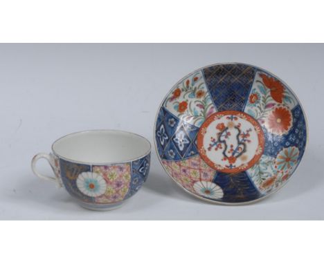 A Worcester Old Mosiak pattern teacup and saucer, decorated with alternating panels of floral roundels and stylised flowers, 