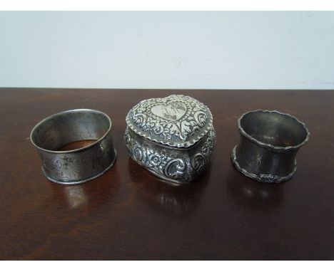 Two silver napkin rings, one of larger proportions, together with a silver heart form trinket box, Birmingham 1897, 118g