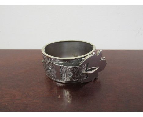 An ornate bangle in white metal