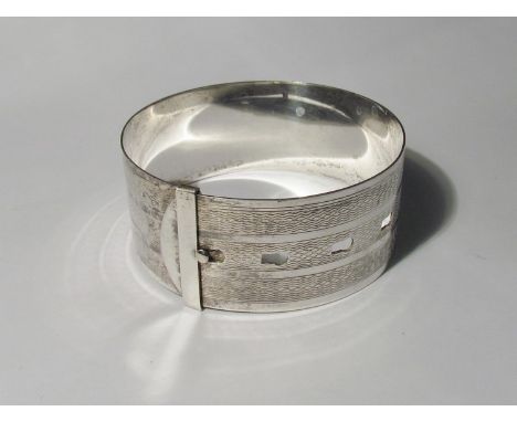 A Sterling marked white metal bangle, engine-turned surround 
