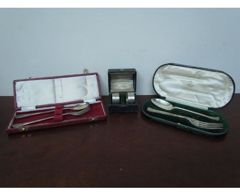 A pair of silver napkin rings and two spoon and fork sets all cased, various makers and dates, 197g