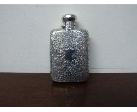 A lady's silver hip flask with all over engraved floral detail, vacant cartouche, top dented, 10cm tall, 69g