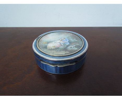 A French silver trinket box,the hand-painted circular top behind glass, blue guilloche case a/f, 9cm diameter