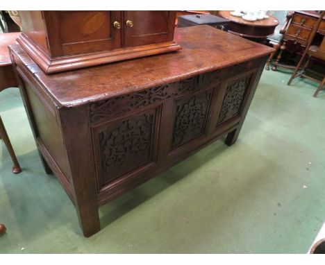 Circa 1700 an oak three panel coffer the hinged top and carved front over stile feet 