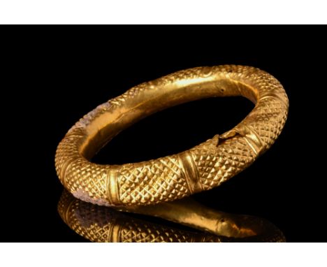 Ca. 5th-7th century AD.A penannular type bracelet with a hollow body, smooth inside and to the outside densely covered with p