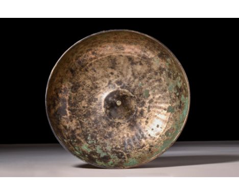 Ca. AD 100-300.A bronze libation bowl featuring an hemispherical body with a raised, conical projection at the centre and an 