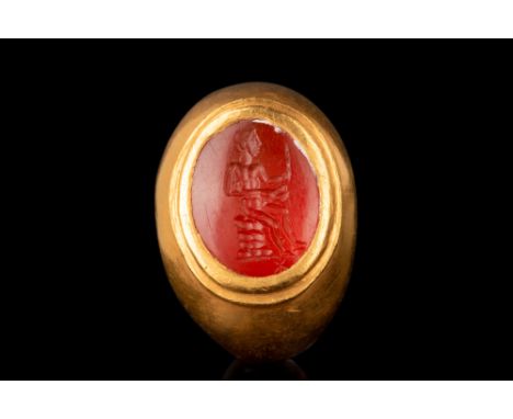 Ca. 1st-2nd century AD.An oval-shaped carnelian intaglio engraved with a nude male figure depicted seated atop a pile of rock