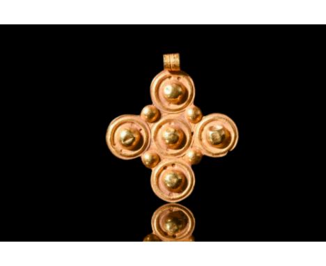 Ca. AD 600.A gold pendant composed of five roundels seamlessly joined to form a cross. Each roundel is distinguished by a cen