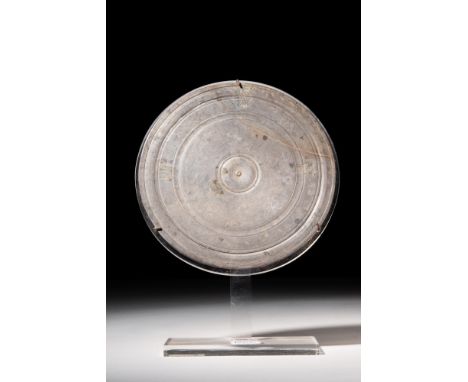 Ca. AD 100 - 300.A beautiful ancient Roman bronze mirror featuring a flat circular body, with a smooth front face, that has n