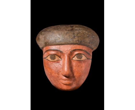 Ca. 664-332 BC.A wooden mask from the lid of an anthropoid coffin, painted in pigment over gesso: dark red for the skin tone,
