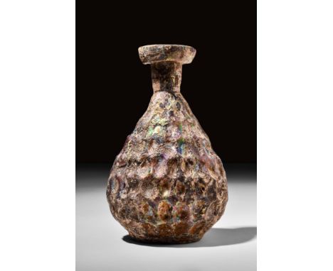 Ca. AD 100-300.A glass flask with beautiful iridescence. It features a piriform body, flattened base, short tubular neck, and