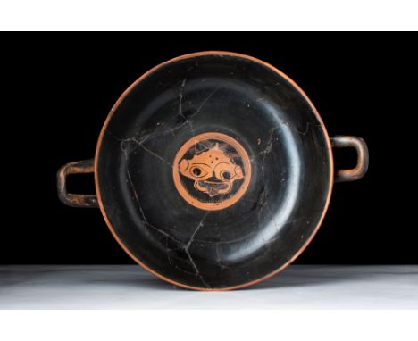 Ca. 500 BC.A beautiful black-figured kylix, attributed to the Leafless group. The frontal face of a Gorgon adorns the tondo, 