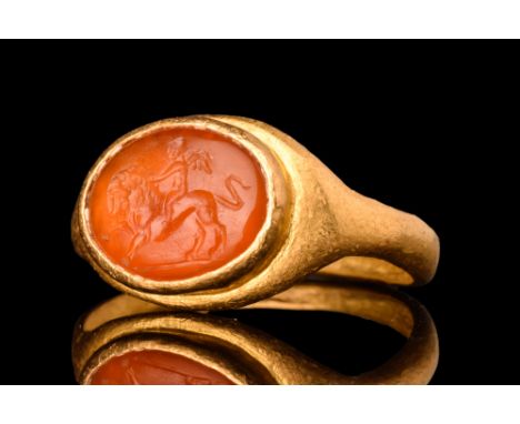 Ca. AD 200.A gold finger ring composed of a flat-section hoop with a raised elliptical cell set with carnelian intaglio. The 