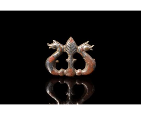 Ca. 2nd century AD.A bronze brooch plate featuring an openwork design of a central stem culminating in a leaf-shaped finial, 