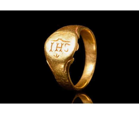 Western Europe, Ca. AD 1500.A gold finger ring with a flat-section hoop and a flattened bezel engraved with an 'IHS' Christog