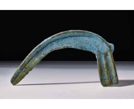 Ca. 2nd millennium BC.A bronze single-edged sickle blade with a rounded tip and a short handle to the end. Sickle blades were