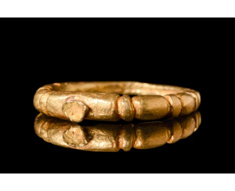 Ca. AD 900-1100.A gold finger ring characterised by a tapering hoop with symmetrically placed incisions on the external edge.