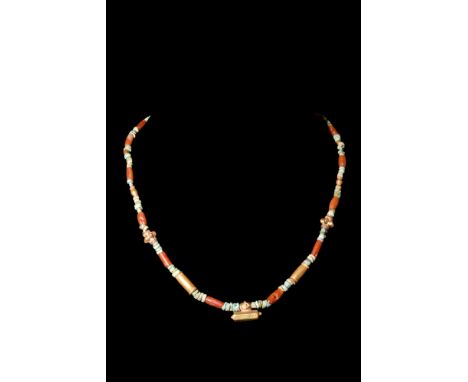 Ca. AD 1-300.A restrung necklace with a symmetrical arrangement of beads. At its centre, a gold pendant serves as a focal poi