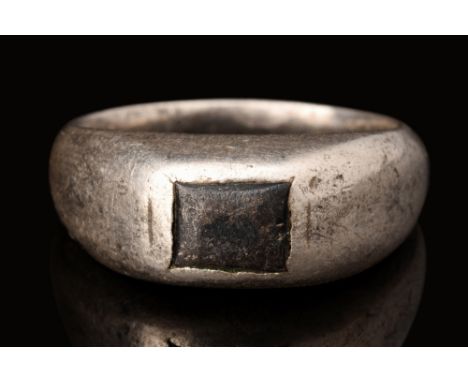 Ca. AD 1700-1800.A silver finger ring with a stirrup profile of a round hoop, expanding at the top to form a bezel. The bezel