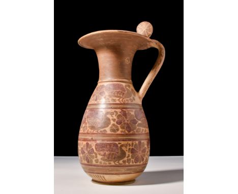 Ca. 600 BC.A pottery olpe with a piriform body, tapering to a slender funnel-shaped neck with an overhanging lip. The vessel 