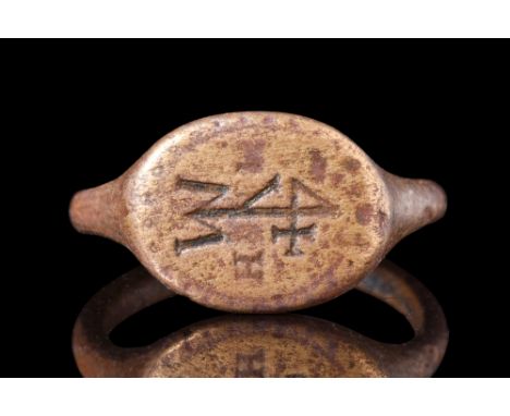 Ca. AD 1500 .A bronze seal ring featuring a smooth and thin band that expands to form a flat, oval-shaped bezel. The bezel is