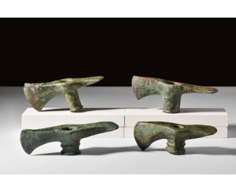 Western Asia, Ca. 2nd millennium BC.A group of four bronze axe heads with an adze blade. Each tool features a central, collar