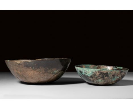 Ca. 5th century BC.A pair of bronze bowls comprising one with a deep, hemispherical body adorned with rosette decoration on t