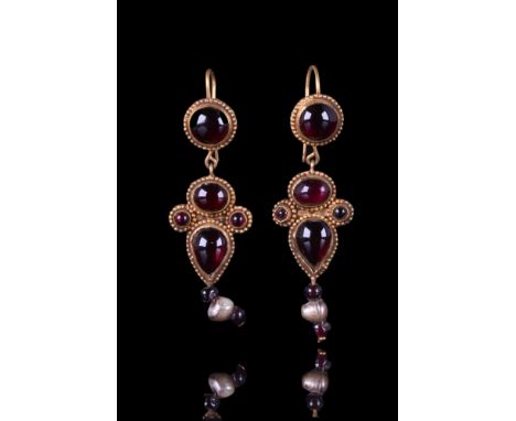 Ca. AD 300-400.A matched pair of gold earrings, each composed of a gold loop and a circular bezel with beaded borders, filled