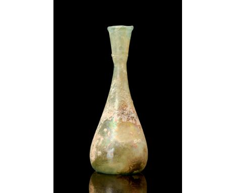 Ca. AD 100-300.A glass flask of a piriform body with a concave base. Seamlessly integrated with the lower body, the cylindric