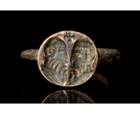 Ca. 4th-7th century AD.A bronze finger ring with a facetted hoop and a circular bezel engraved with the profile busts of the 