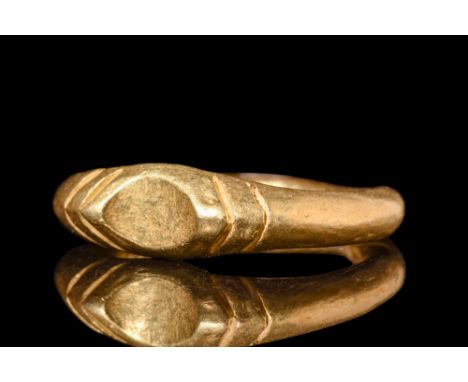 Ca. AD 900-1100.A gold finger ring formed as a hollow hoop with a tapered back and expanded shoulders. Pairs of chevron incis