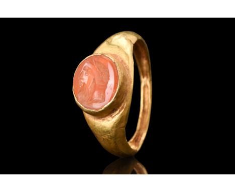 Ca. AD 200-300.A gold finger ring with a carnelian portrait intaglio of Jupiter seen in profile and wearing a laurel crown. I