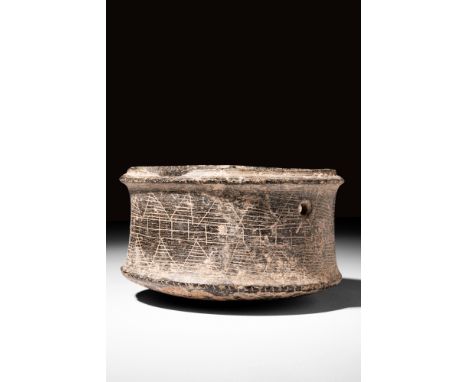 Ca. 3rd-2nd millennium BC.A stone vessel characterised by its cylindrical shape, featuring slightly corsetted walls that rise