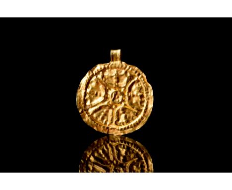Ca. AD 700-800.A circular pendant crafted from a thin sheet of gold. This amulet features a suspension loop for attachment an