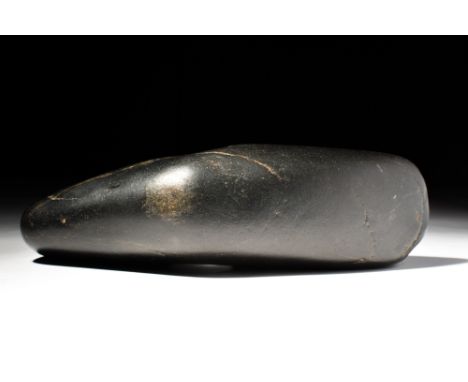 Ca. 2800 - 1700 BC.A Danish Neolithic black hard stone axe head, of the boat-axe type, drilled through the center with a shaf