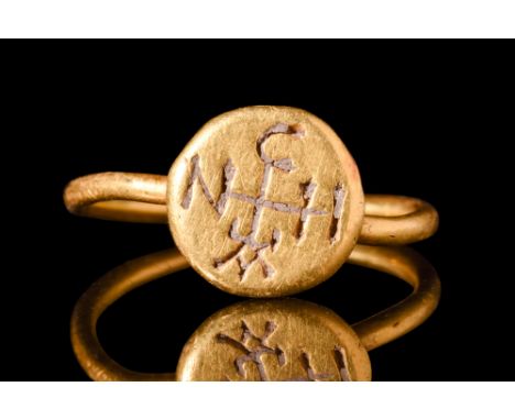 Ca. AD 500-600.A gold ring featuring a discoid bezel joined to a solid round-section hoop and decorated with an engraved desi