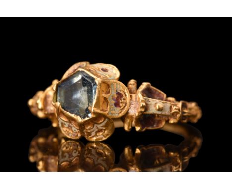 Ca. AD 1600.A gold finger ring with a thin, round section hoop gracefully flaring at the shoulders. The raised bezel features