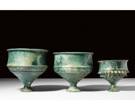 Ca. AD 500.A group of three bronze goblets, each with a conical-shaped cup with an outward flaring rim and two circumferentia