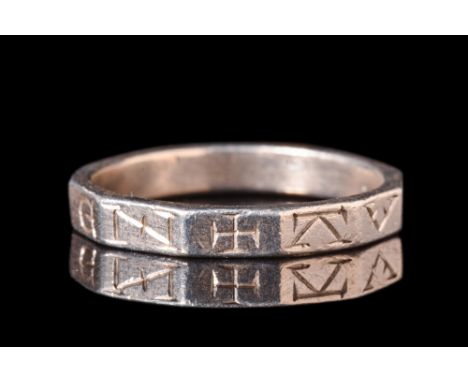 Ca. AD 400.A silver finger band with a polygonal profile featuring letters inscribed on each facet and a cross mark. Silver r