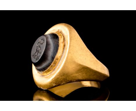 Ca. AD 1-200.An oval-shaped onyx intaglio with bevelled edges and an engraved depiction of a legionary eagle standing atop a 