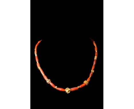 Ca. AD 1-300.A restrung necklace composed of an interweaving pattern of long, cylindrical carnelian beads and variously shape