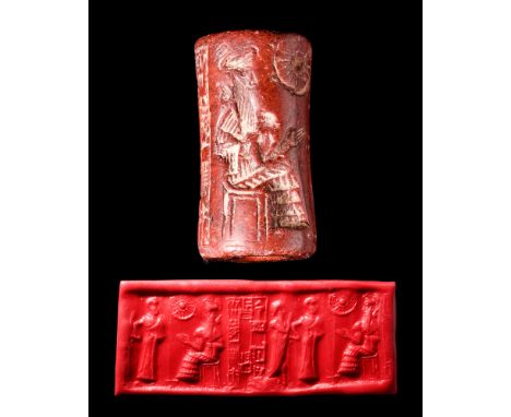 Ca. 2100 BC. A brownish stone cylinder seal depicting a seated solar deity and a bald-headed attendant. Accompanied by a Neo-