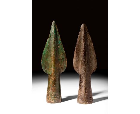 Ca. 600 BC. A pair of cast bronze spearheads, each exhibits a leaf-shaped blade with a pronounced mid-rib, pointed tip, and d