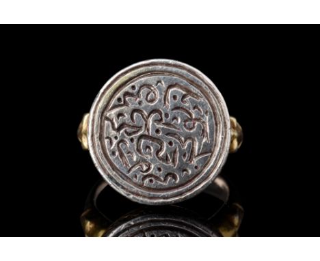 Ca. early 14th century AD.A silver gilt finger ring formed of a slender incised band featuring a square-shaped protrusion at 