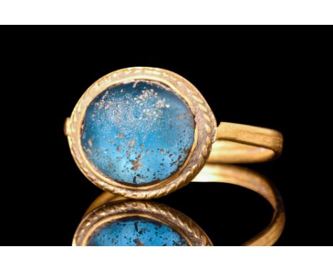 Ca.7th century AD.A gold finger ring with a thin, flat-section hoop of a D-shaped profile. The ring is adorned with a flat be