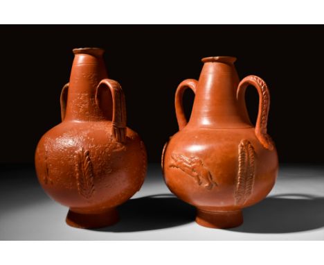 Ca. 3rd century AD.A pair of redware amphoriskoi, crafted through a wheel-throwing technique. Each vessel features a concave 