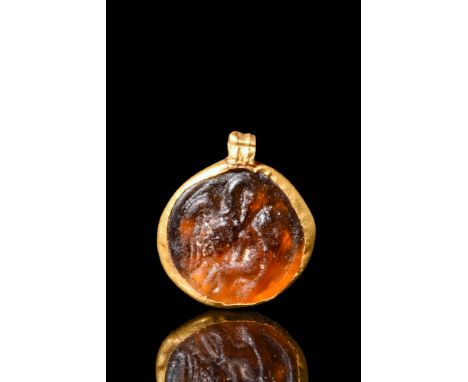 Ca. 2nd-3rd century AD.A glass medallion with a relief scene of Leda and the Swan set in a gold pendant setting. Leda, a prin