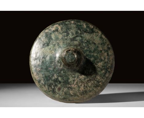 Ca. AD 100-300.A bronze umbo, or shield boss, assumes a circular form with a raised, domed centre and a broad, flat flange. T